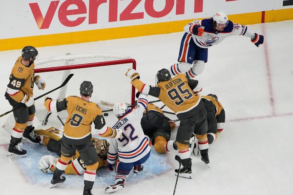 Edmonton Oilers right wing Kasperi Kapanen, upper right, celebrates after scoring against the Vegas Golden Knights during overtime of Game 5 of a second-round NHL hockey playoff series Wednesday, May 14, 2025, in Las Vegas. (AP Photo/John Locher)