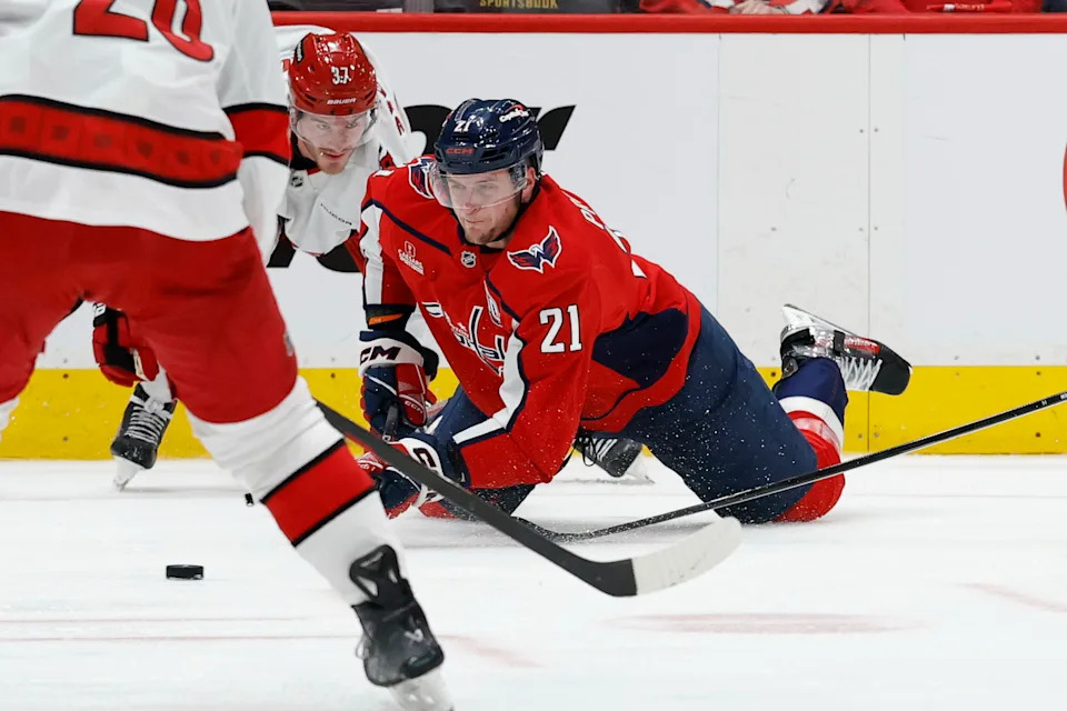 May 6, 2025; Washington, District of Columbia, USA; Washington Capitals center Aliaksei Protas (21) attempts to shoot the puck after being knocked down by Carolina Hurricanes right wing Andrei Svechnikov (37) in the third period in game one of the second round of the 2025 Stanley Cup Playoffs at Capital One Arena. Mandatory Credit: Geoff Burke-Imagn Images