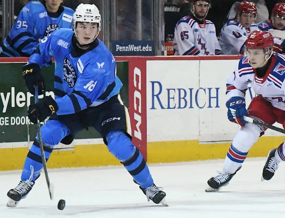 Erie Otters defenseman Matthew Schaefer, left, controls the puck near Kitchener Rangers forward Adrian Misaljevic at Erie Insurance Arena in Erie on Nov. 23, 2024.