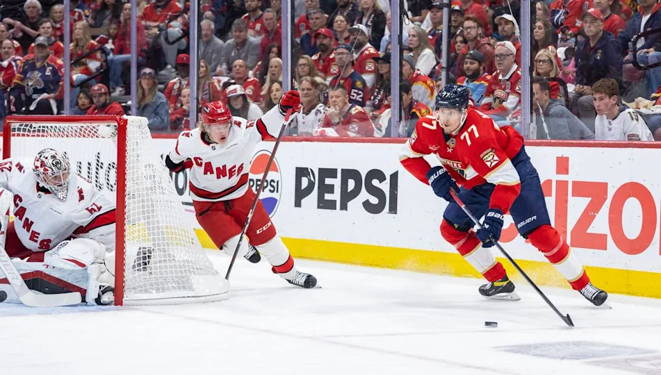 Florida Panthers defenseman Niko Mikkola (77) looks to pass the puck as Carolina Hurricanes goaltender Pyotr Kochetkov (52) and right wing Jackson Blake (53) defend in the first period of Game 3 during the Eastern Conference final of the NHL Stanley Cup playoffs at Amerant Bank Arena on Saturday, May 24, 2025, in Sunrise, Fla.
