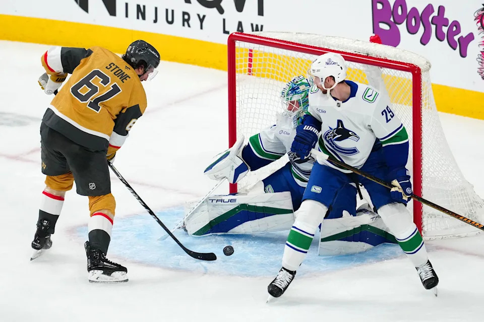Vegas Golden Knights right wing Mark Stone (61) shoots against Vancouver Canucks goaltender Kevin Lankinen (32) in front of Vancouver Canucks defenseman Marcus Pettersson (29) during the third period at T-Mobile Arena. Mandatory Credit: Stephen R. Sylvanie-Imagn Images