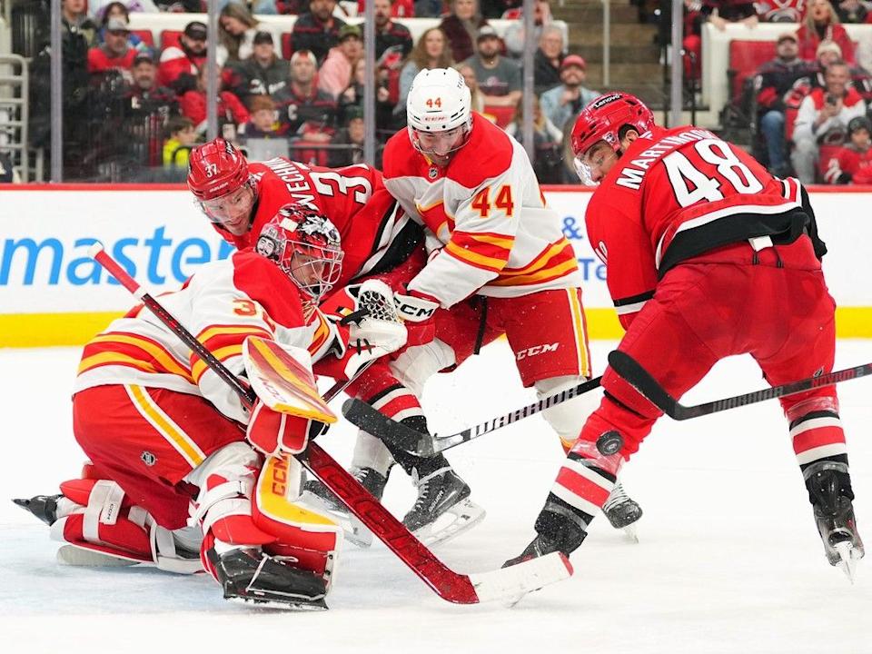  Calgary Flames goaltender Dustin Wolf deflects a shot by Carolina Hurricanes forward Jordan Martinook at Lenovo Center in Raleigh, N.C., on Sunday, March 2, 2025.