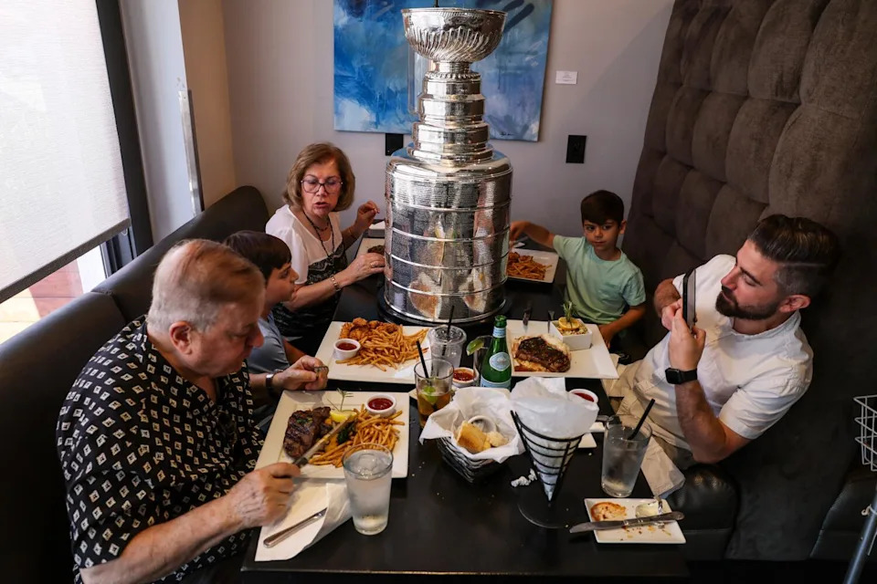 Nareg Dekermenjian and his family eat lunch while the Stanley Cup sits in the middle of the table.