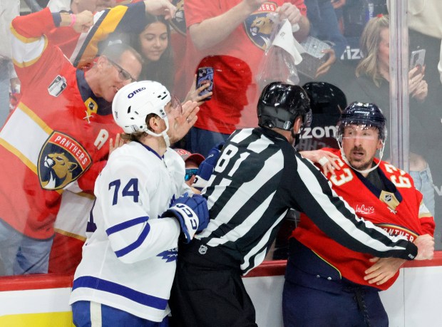 Officials separate Toronto Maple Leafs center Bobby McMann (74) and...