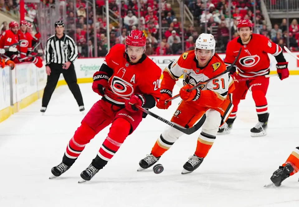 Carolina Hurricanes center Sebastian Aho (20) and Anaheim Ducks defenseman Olen Zellweger (51) watch the puck during the third period at Lenovo Center. James Guillory-Imagn Images