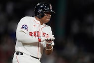 Boston Red Sox's Rafael Devers celebrates while heading down the first base line on his...