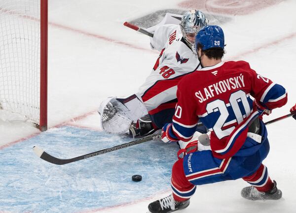 Montreal Canadiens' Juraj Slafkovsky (20) scores against Washington Capitals goaltender Logan Thompson (48) during the third period of Game 3 of a first-round NHL hockey playoff series in Montreal, Friday, April 25, 2025. (Christinne Muschi/The Canadian Press via AP)