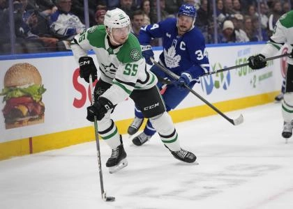 Dallas Stars defenseman Thomas Harley skating past Toronto Maple Leafs forward Auston Matthews.