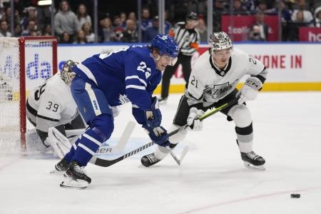 Los Angeles Kings defenseman Jordan Spence and Toronto Maple Leafs forward Matthew Knies engaged in a net-front battle. Los Angeles Kings defenseman Jordan Spence and Toronto Maple Leafs forward Matthew Knies engaged in a net-front battle.