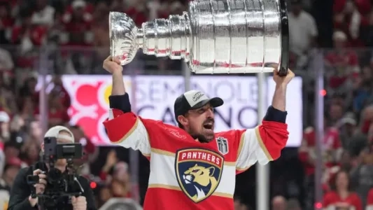 Florida Panthers forward Brad Marchand hoisting the Stanley Cup.