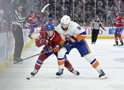 Jan 25, 2024; Montreal, Quebec, CAN; Montreal Canadiens forward Cole Caufield (22) and New York Islanders defenseman Noah Dobson (8) battle for the puck during the third period at the Bell Centre. Mandatory Credit: Eric Bolte-Imagn Images