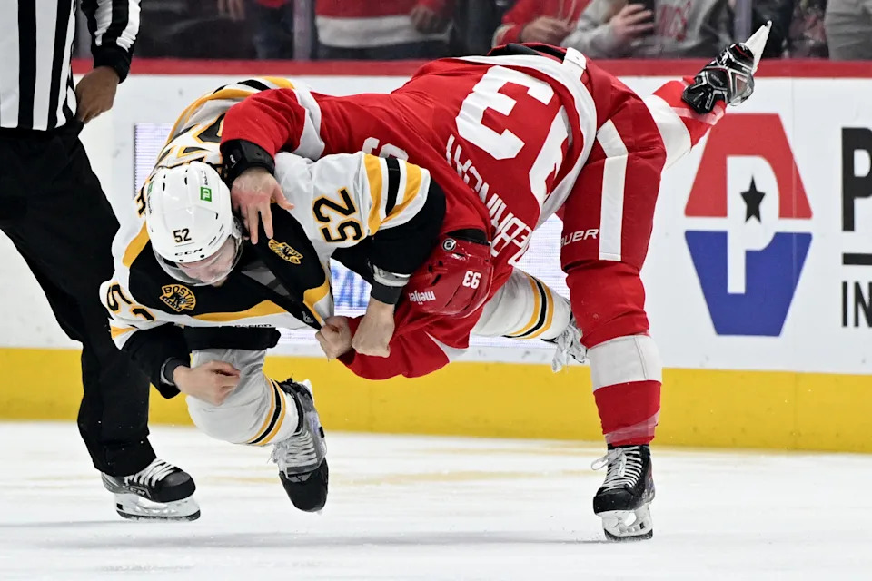 Boston Bruins defenseman Andrew Peeke (52) and Detroit Red Wings right wing Alex DeBrincat (93) fight in the first period at Little Caesars Arena in Detroit on Saturday, March 29, 2025.