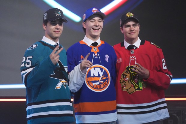 Matthew Schaefer, drafted first by the New York Islanders, middle, stands between Michael Misa, drafted second by the San Jose Sharks, left, and Anton Frondell, drafted third by the Chicago Blackhawks, during the NHL hockey draft Friday, June 27, 2025, in Los Angeles. (AP Photo/Damian Dovarganes)