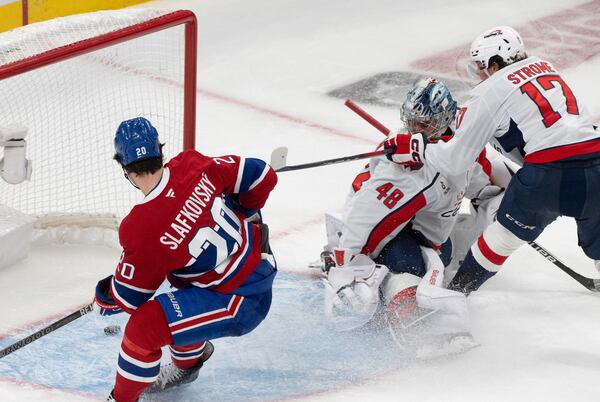 Montreal Canadiens' Juraj Slafkovsky (20) scores against Washington Capitals goaltender Logan Thompson (48) as Capitals' Dylan Strome (17) skates in during the third period of Game 3 of a first-round NHL hockey playoff series in Montreal, Friday, April 25, 2025. (Christinne Muschi/The Canadian Press via AP)