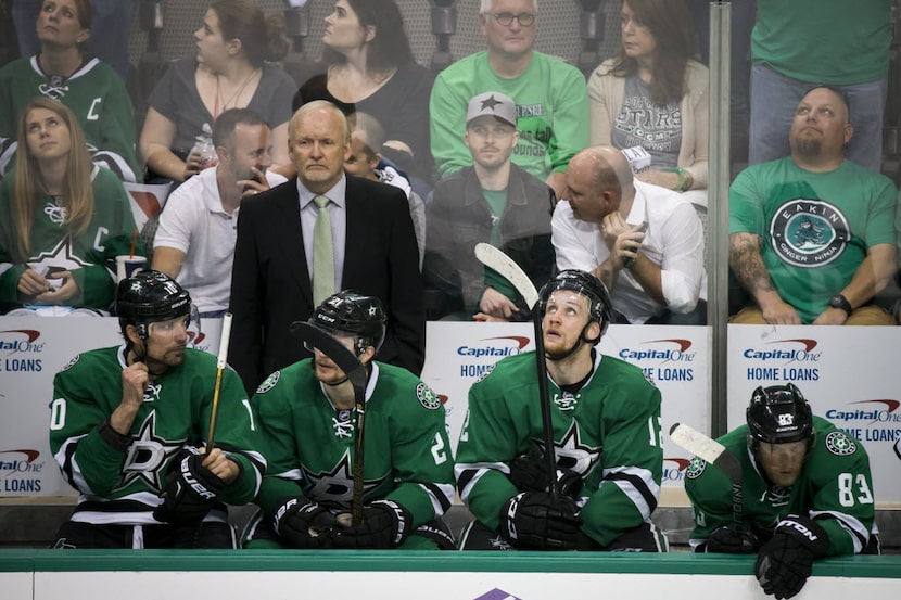 Dallas Stars head coach Lindy Ruff stands over a somber bench during the third period of a...