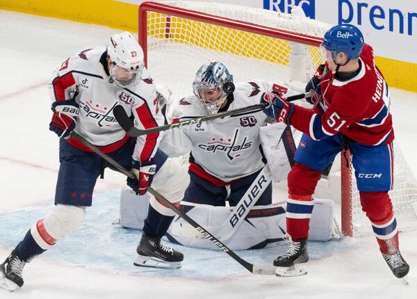 Montreal Canadiens' Emil Heineman (51) looks for a rebound in front of Washington Capitals goaltender Logan Thompson, center, and Alexander Alexeyev (27) during the second period of Game 3 of a first-round NHL hockey playoff series in Montreal, Friday, April 25, 2025. (Christinne Muschi/The Canadian Press via AP)