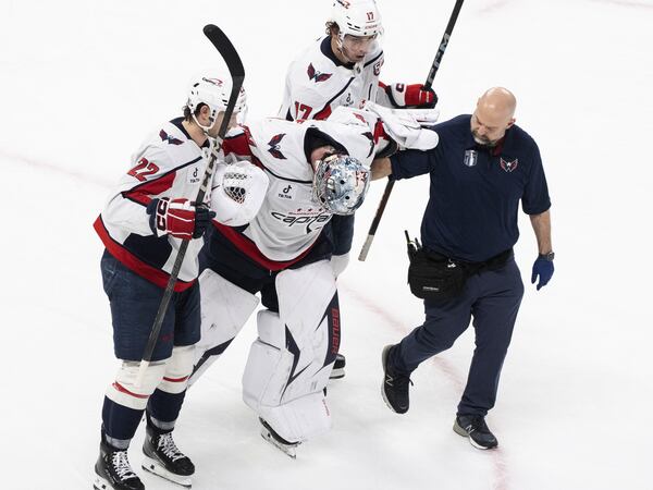 Washington Capitals goaltender Logan Thompson, center front, is helped off the ice during the third period of Game 3 of a first-round NHL hockey playoff series against the Montreal Capitalls in Montreal, Friday, April 25, 2025. (Christinne Muschi/The Canadian Press via AP)