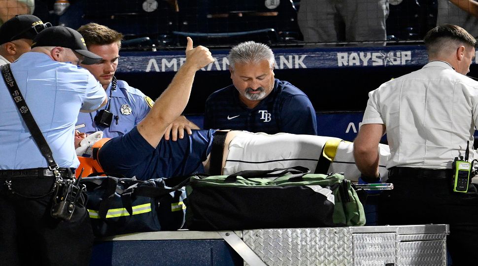 Tampa Bay Rays' Hunter Bigge gives a thumbs up as paramedics tend to him after being hit by a foul ball while in the dugout during the seventh inning of a baseball game against the Baltimore Orioles, Thursday, June 19, 2025, in Tampa, Fla. (AP Photo/Jason Behnken)