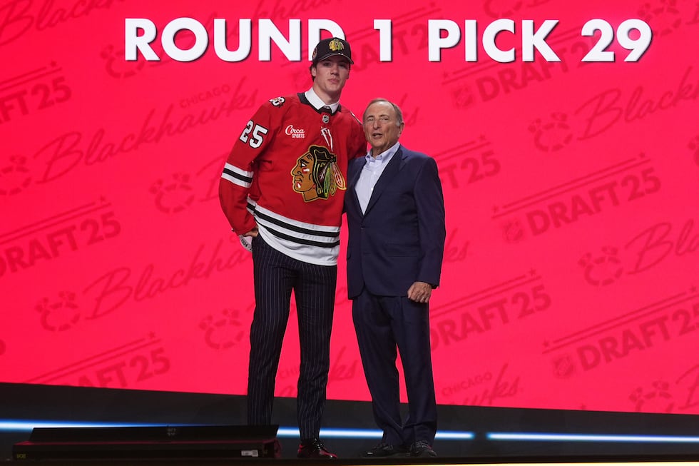 Mason West, left, stands with NHL commissioner Gary Bettman after being drafted by the Chicago...