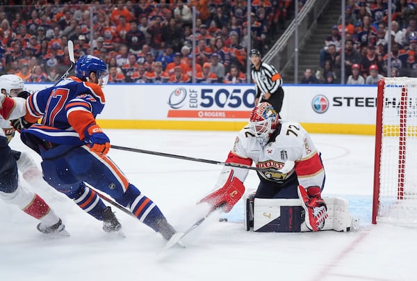 Florida Panthers goalie Sergei Bobrovsky (72) stops Edmonton Oilers' Connor McDavid (97) during the first overtime period in Game 2 of the NHL Stanley Cup Final, in Edmonton, Alberta, Friday, June 6, 2025. (Darryl Dyck/The Canadian Press via AP)