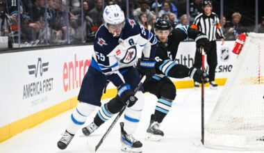 Mark Scheifele #55 of the Winnipeg Jets skates the puck away from John Marino #6 of the Utah Hockey...