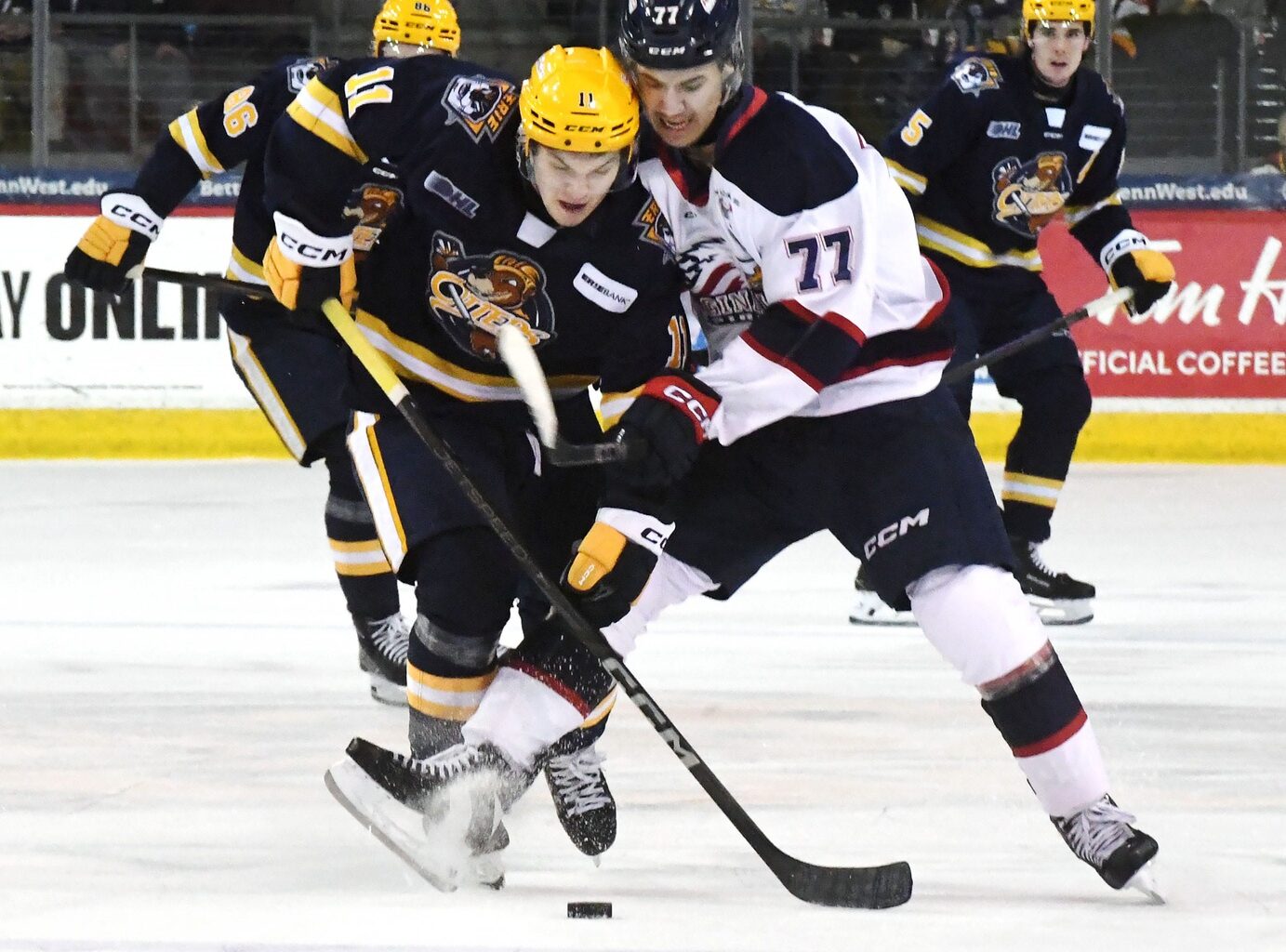 Erie Otters forward Dylan Edwards, leftt, competes against Saginaw Spirit forward Michael Misa during an Ontario Hockey League playoff game at Erie Insurance Arena in Erie on April 1, 2025.