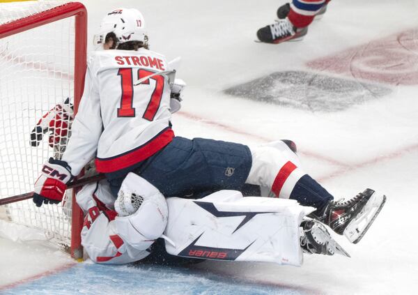 Washington Capitals' Dylan Strome (17) collides with goaltender Logan Thompson, bottom, during the third period of Game 3 of a first-round NHL hockey playoff series against the Montreal Canadiens in Montreal, Friday, April 25, 2025. (Christinne Muschi/The Canadian Press via AP)