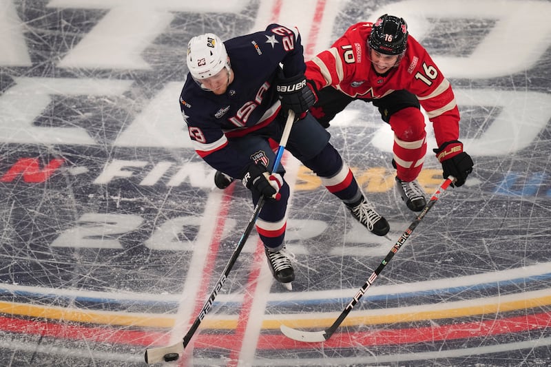 United States' Adam Fox, left, battles Canada's Mitch Marner for the puck during the first period of the 4 Nations Face-Off championship hockey game, Thursday, Feb. 20, 2025, in Boston.