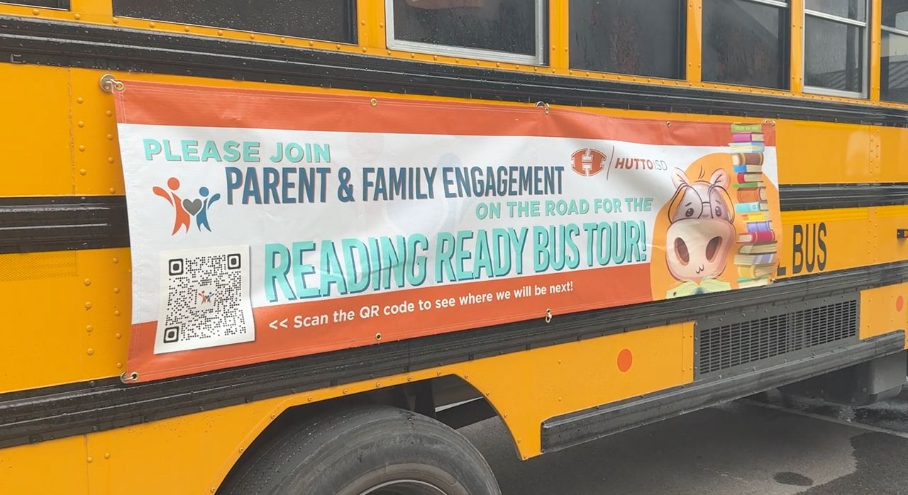 Yellow school bus with banner on its side reading 