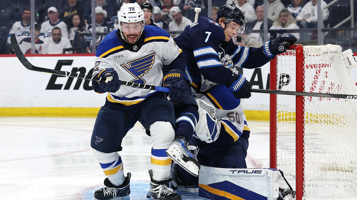 St. Louis Blues defenseman Justin Faulk (72) chases a rebound as Winnipeg Jets center Vladislav Namestnikov (7) and St. Louis Blues goaltender Jordan Binnington (50) are tangled up in the second period in game two of the first round of the 2025 Stanley Cup Playoffs at Canada Life Centre.