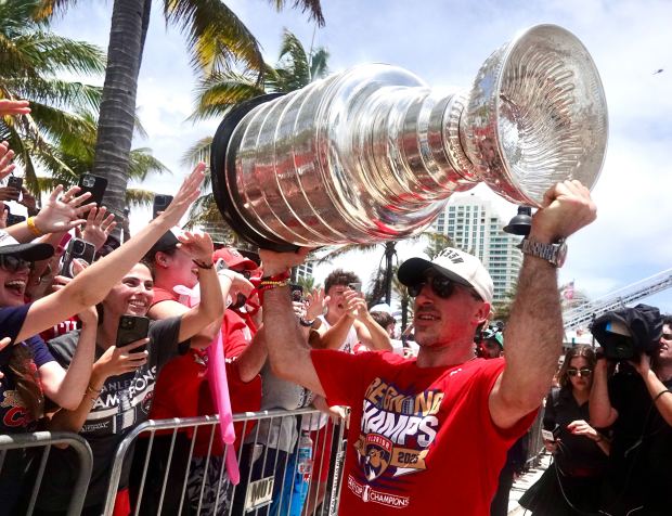 Brad Marchand of the Florida Panthers hoists the Stanley Cup in front of the crowd along the championship parade route on Fort Lauderdale beach on Sunday. (Joe Cavaretta/South Florida Sun Sentinel)