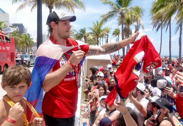 Florida Panthers’ Dmitry Kulikov greets fans along the route of...