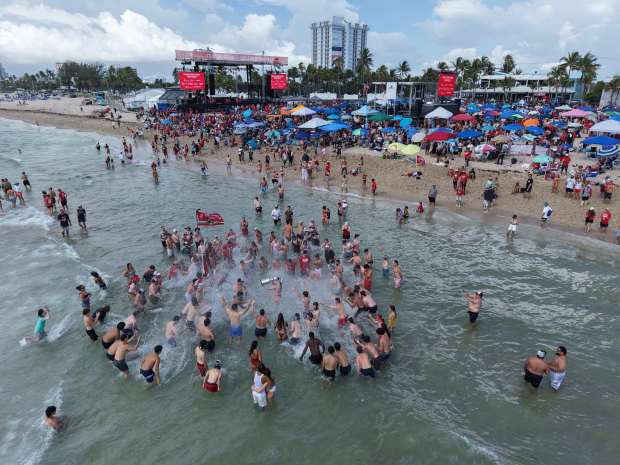 Fans celebrate with a replica Stanley Cup in the water as they wait for the start of the Panthers championship parade on Fort Lauderdale Beach. (Sean Pitts/South Florida Sun Sentinel)