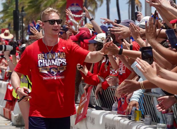 Florida Panthers’ Gustav Forsling greets fans along the route of...