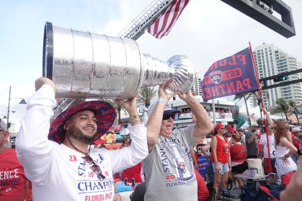 Fans carry a Stanley Cup replica in front of the Elbo Room at the corner of State Road A1A and Las Olas Boulevard before the start of the Florida Panthers victory parade on Sunday, June 22, 2025. (Joe Cavaretta/South Florida Sun Sentinel)