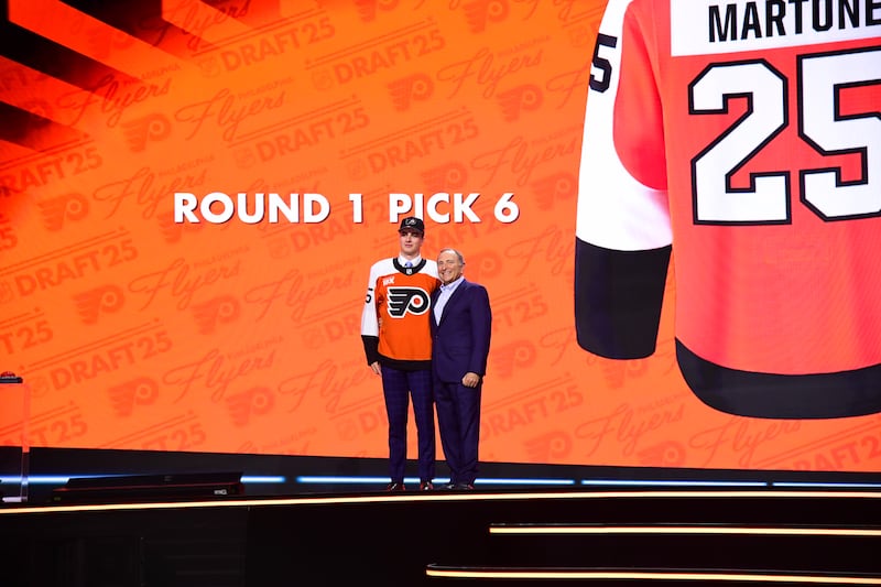 LOS ANGELES, CALIFORNIA - JUNE 27: Porter Martone stands onstage with NHL Commissioner Gary Bettman after being selected sixth overall by the Philadelphia Flyers during the 2025 NHL Draft at Peacock Theater on June 27, 2025 in Los Angeles, California. (Photo by Adam Pantozzi/NHLI via Getty Images)