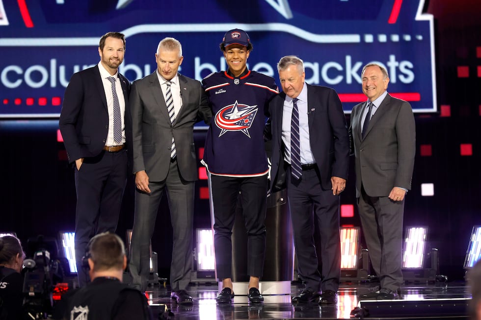 Cayden Lindstrom, center, poses after being selected by the Columbus Blue Jackets during the...