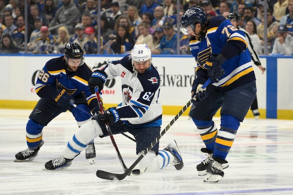 Winnipeg Jets right wing Nino Niederreiter (62) battles St. Louis Blues left wing Nathan Walker, left, and defenseman Justin Faulk, right, during the first period in Game 6 of an NHL hockey first-round playoff series Friday, May 2, 2025, in St. Louis. (AP Photo/Jeff Le)