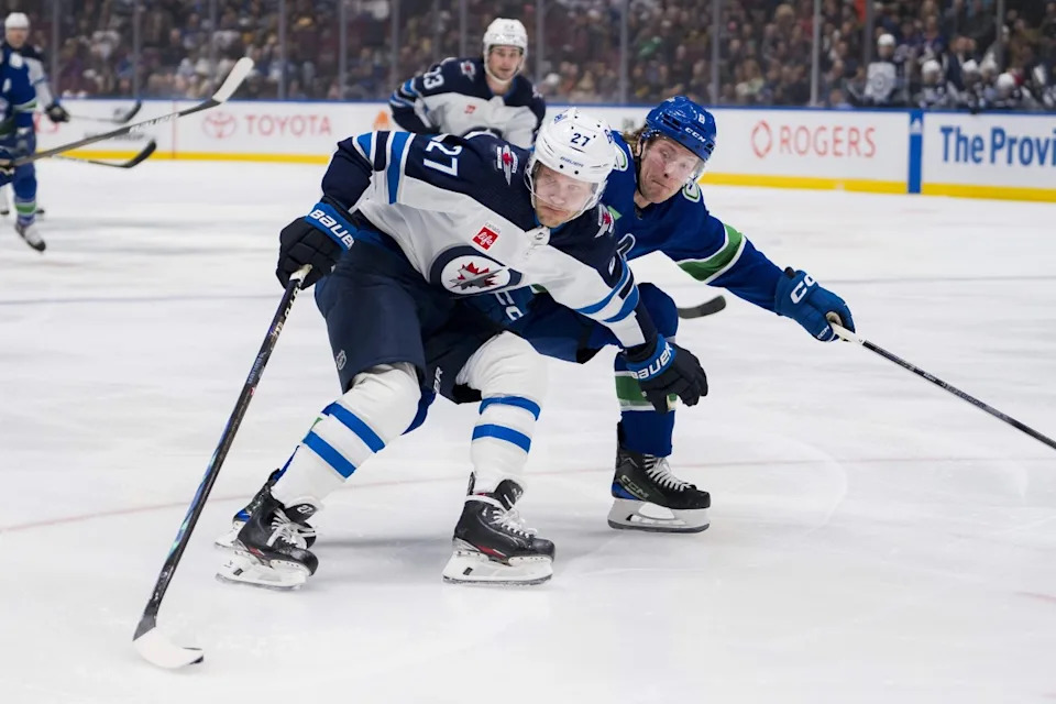 Vancouver Canucks forward Brock Boeser (6) checks Winnipeg Jets forward Nikolaj Ehlers (27) in the first period at Rogers Arena.Bob Frid-Imagn Images