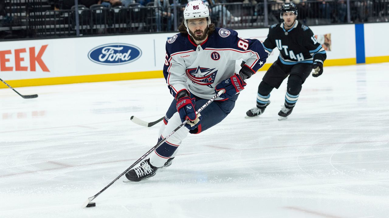Columbus Blue Jackets right wing Kirill Marchenko (86) skates with the puck against Utah Hockey Club center Alexander Kerfoot (15) during the first period of an NHL hockey game Friday, Jan. 31, 2025, in Salt Lake City. (AP Photo/Melissa Majchrzak)