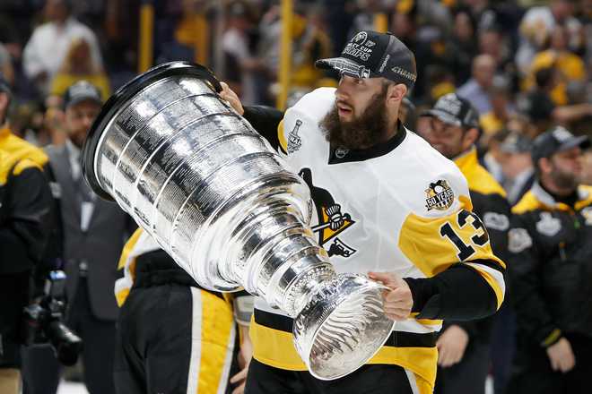 NASHVILLE, TN - JUNE 11:  Nick Bonino #13 of the Pittsburgh Penguins celebrates with the Stanley Cup trophy after they defeated the Nashville Predators 2-0 in Game Six of the 2017 NHL Stanley Cup Final at the Bridgestone Arena on June 11, 2017 in Nashville, Tennessee.  (Photo by Justin K. Aller/Getty Images)