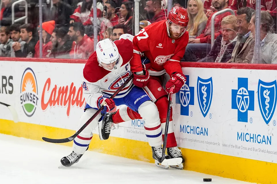 Detroit Red Wings left wing J.T. Compher (37) is checked by Montreal Canadiens center Nick Suzuki (14) during the first period at Little Caesars Arena in Detroit on Thursday, Jan. 23, 2025.