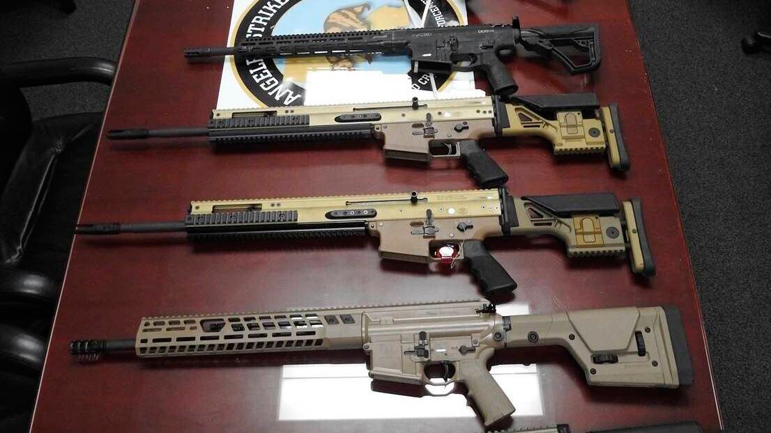 This undated photo provided by the United States Department of Justice shows high-powered firearms and ammo. Six men were charged with plotting to smuggle assault weapons and hundreds of thousands of rounds of ammunition, including .50-caliber armor piercing bullets, to one of Mexico's most violent drug cartels, authorities announced Monday, Jan. 24, 2022. (USDOJ via AP)