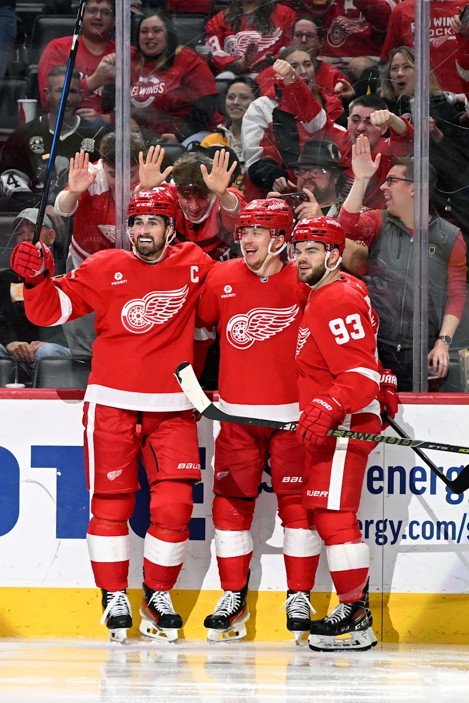 Detroit Red Wings left wing Lucas Raymond (23) celebrates with Detroit Red Wings center Dylan Larkin (71) and Detroit Red Wings right wing Alex DeBrincat (93) after scoring a power play goal against the Boston Bruins in the second period at Little Caesars Arena in Detroit on Saturday, March 29, 2025.