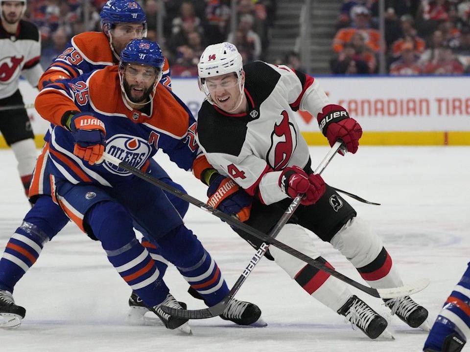  Edmonton Oilers Darnell Nurse (25) battles for the puck with New Jersey Devils Nathan Bastian (14) during second period NHL action on Sunday, Dec. 10, 2023 in Edmonton. Greg Southam-Postmedia