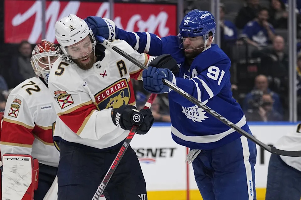 Toronto Maple Leafs forward John Tavares (91) checks Florida Panthers defenseman Aaron Ekblad.John E. Sokolowski-Imagn Images
