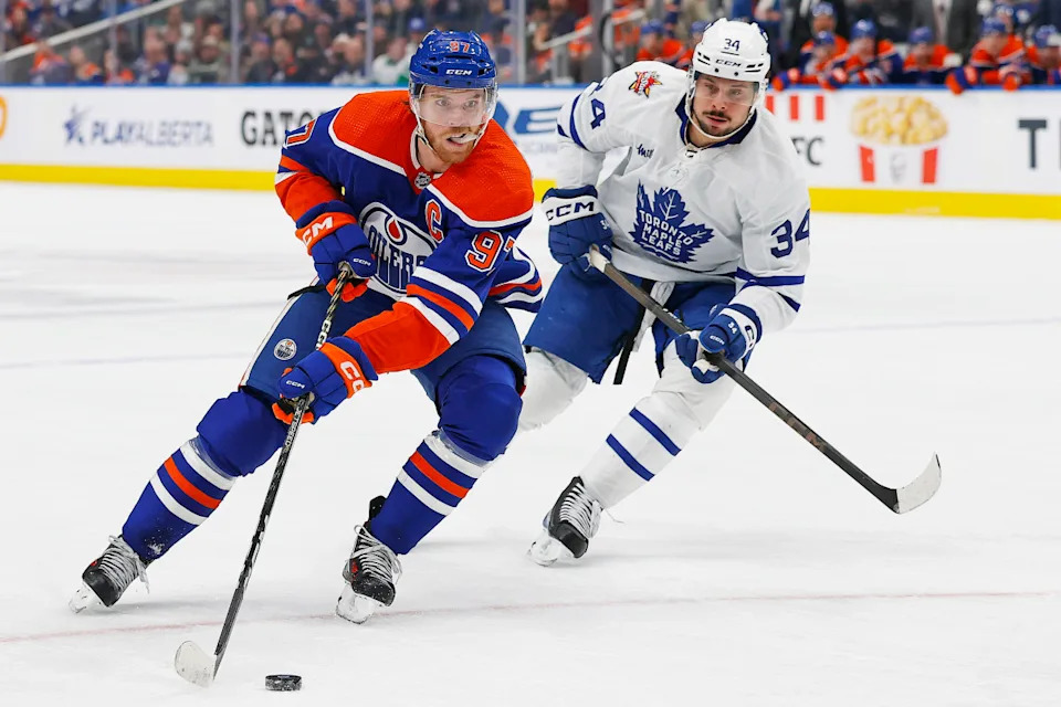 Edmonton Oilers forward Connor McDavid carries the puck around Toronto Maple Leafs forward Auston Matthews.Perry Nelson-Imagn Images