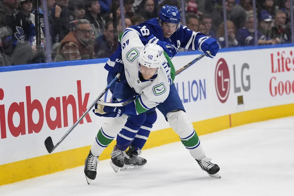 Toronto Maple Leafs forward Mitch Marner (16) tries to slow up Vancouver Canucks forward Elias Pettersson (40) during the third period at Scotiabank Arena.John E&period; Sokolowski-Imagn Images