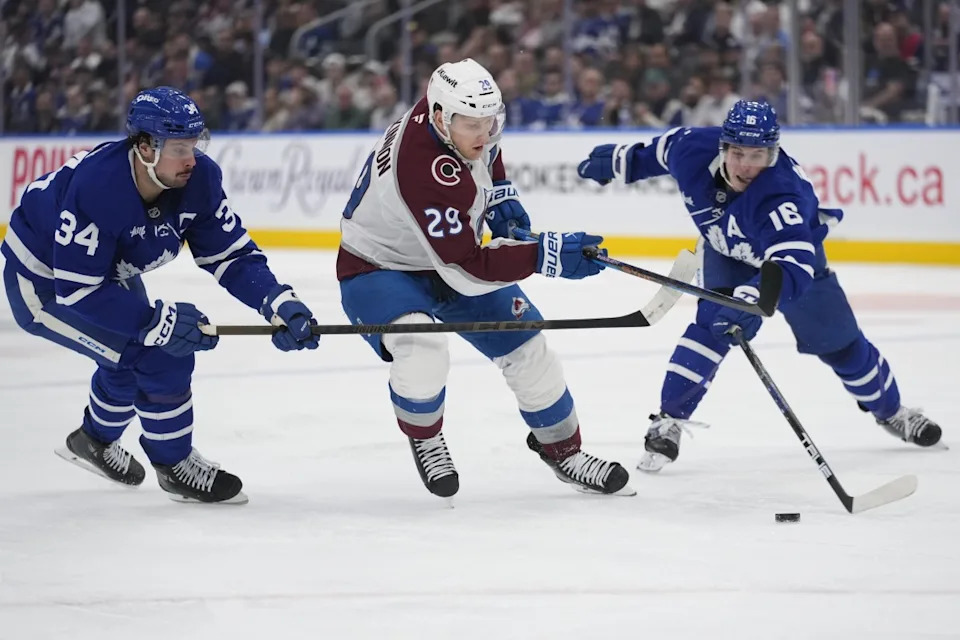 Colorado Avalanche forward Nathan MacKinnon (29) tries to get past Toronto Maple Leafs forward Auston Matthews (34) and forward Mitch Marner (16) during the second period at Scotiabank Arena. John E&period; Sokolowski-Imagn Images