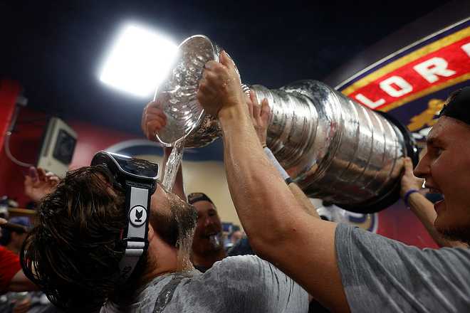 SUNRISE, FLORIDA - JUNE17: Dmitry Kulikov #7 of the Florida Panthers celebrates their Stanley Cup win in the locker room during their team celebration after beating the Edmonton Oilers in Game Six of the 2025 Stanley Cup Final at the Amerant Bank Arena on June 17, 2025 in Sunrise, Florida. (Photo by Eliot J. Schechter/NHLI via Getty Images)